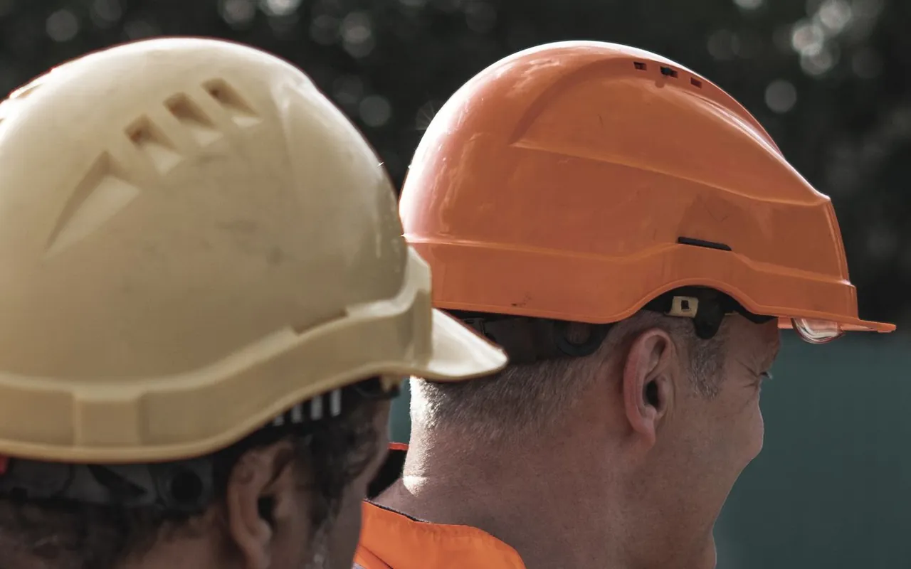 Dos trabajadores con casco y chaleco de alta visibilidad
